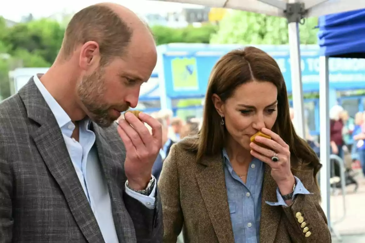 El príncipe Guillermo y Kate Middleton están oliendo frutas en un evento al aire libre. El príncipe Guillermo y Kate Middleton están oliendo frutas en un evento al aire libre.