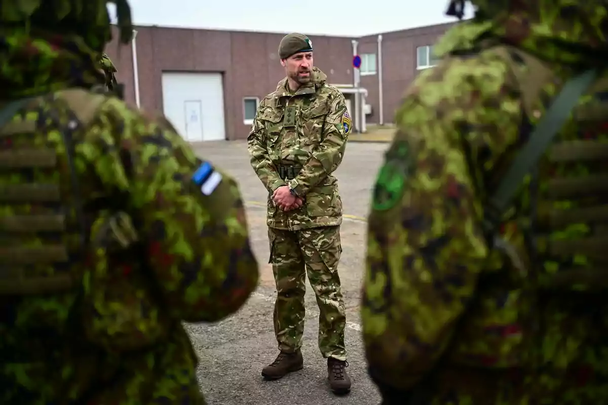 El príncipe Guillermo de pie con uniforme de camuflaje habla frente a otros soldados en un área exterior junto a un edificio El príncipe Guillermo de pie con uniforme de camuflaje habla frente a otros soldados en un área exterior junto a un edificio