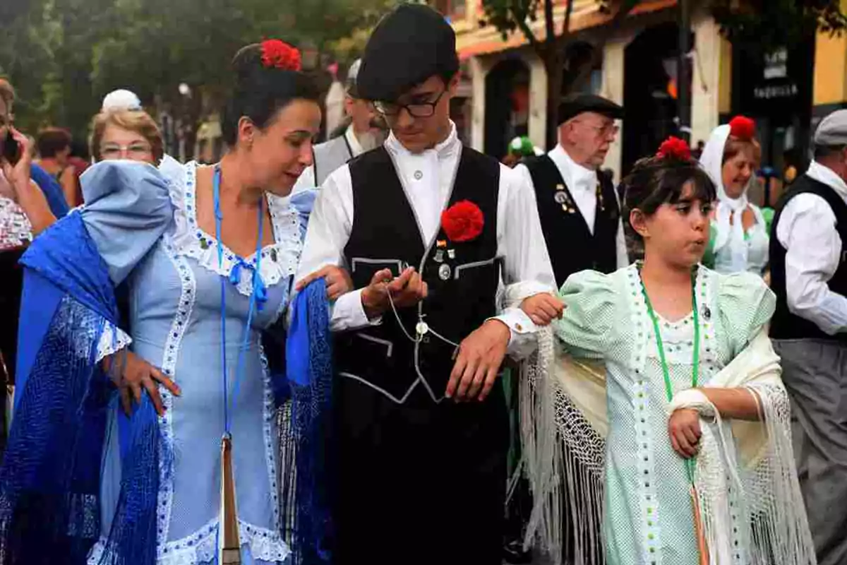 Personas vestidas con trajes tradicionales participan en un evento cultural al aire libre.