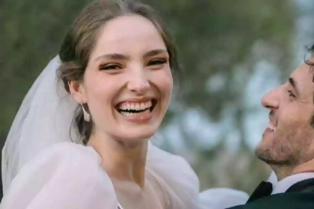 Una novia sonriente junto a su pareja en el día de su boda.