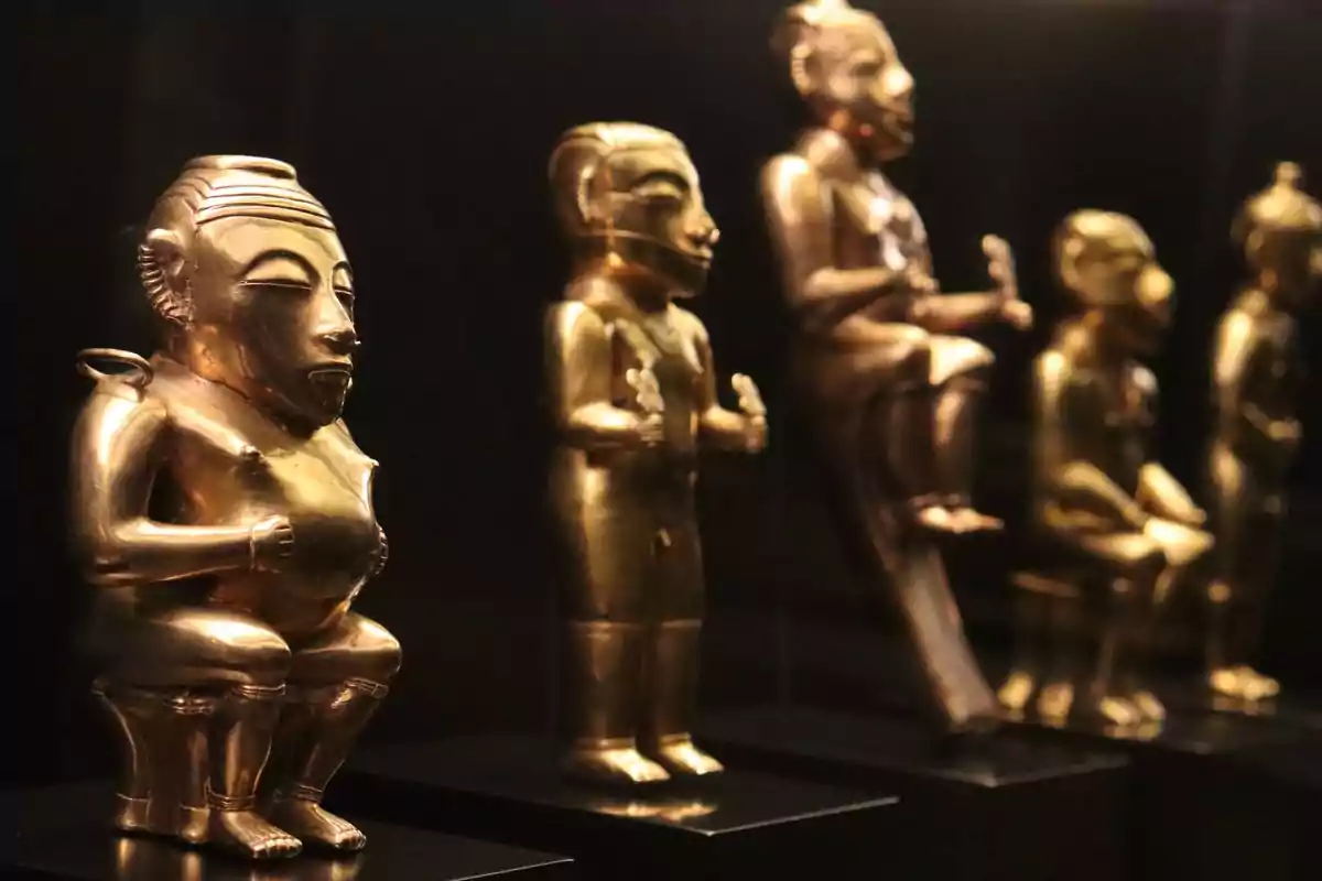 Figuras de oro precolombinas en exhibición en un museo.