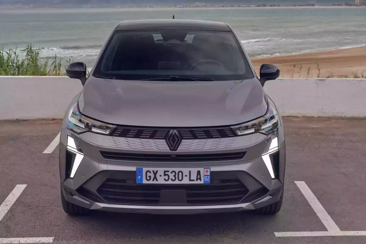 Un Renault Symbioz Hybrid gris estacionado frente a una playa con el océano de fondo. Un Renault Symbioz Hybrid gris estacionado frente a una playa con el océano de fondo.