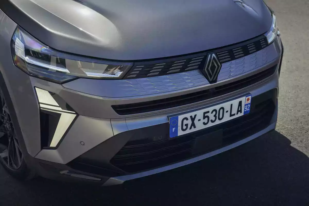 Frontal de un Renault Symbioz Hybrid gris con una placa de matrícula visible y un diseño moderno en la parrilla. Frontal de un Renault Symbioz Hybrid gris con una placa de matrícula visible y un diseño moderno en la parrilla.