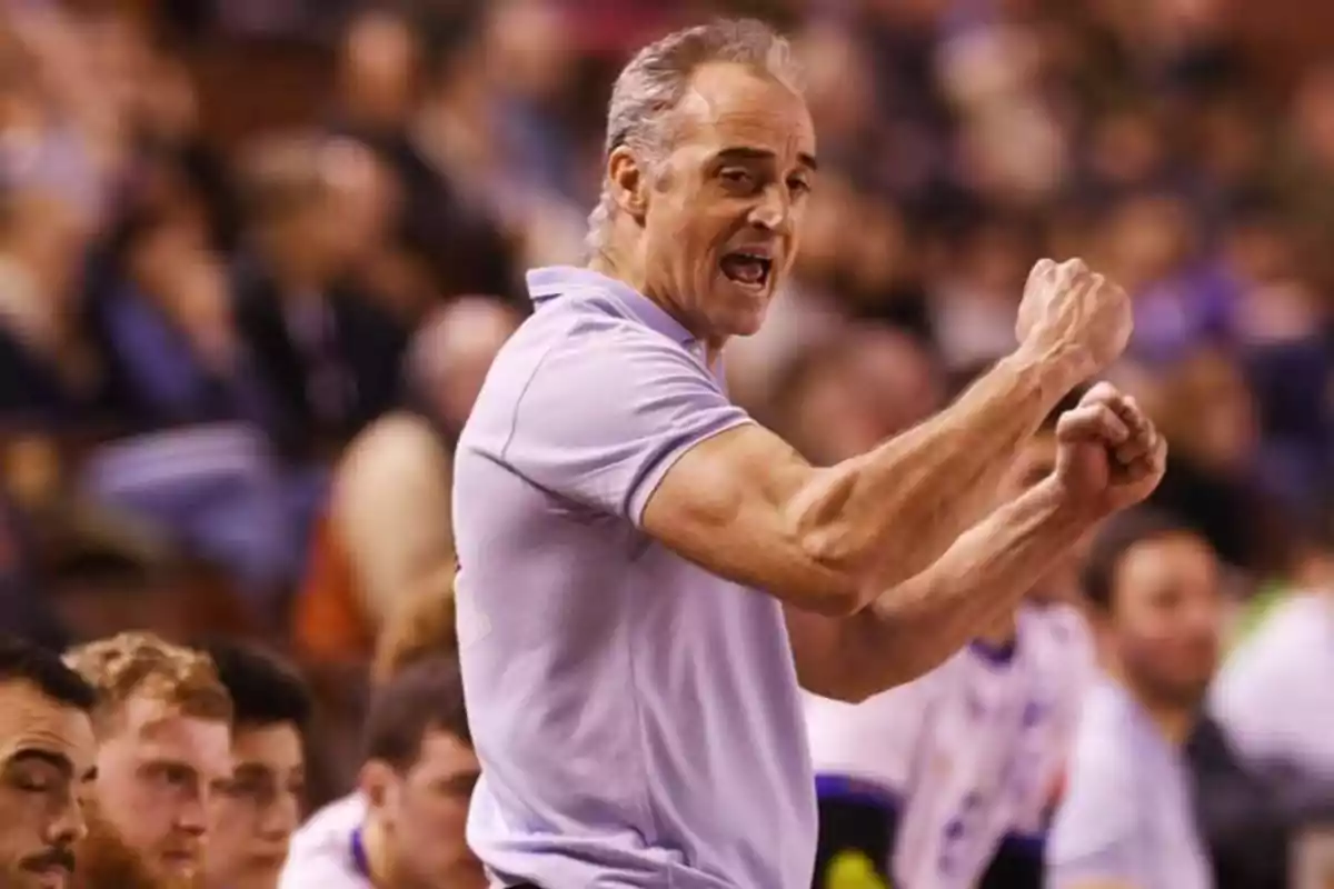 Entrenador de baloncesto animando enérgicamente a su equipo durante un partido Entrenador de baloncesto animando enérgicamente a su equipo durante un partido
