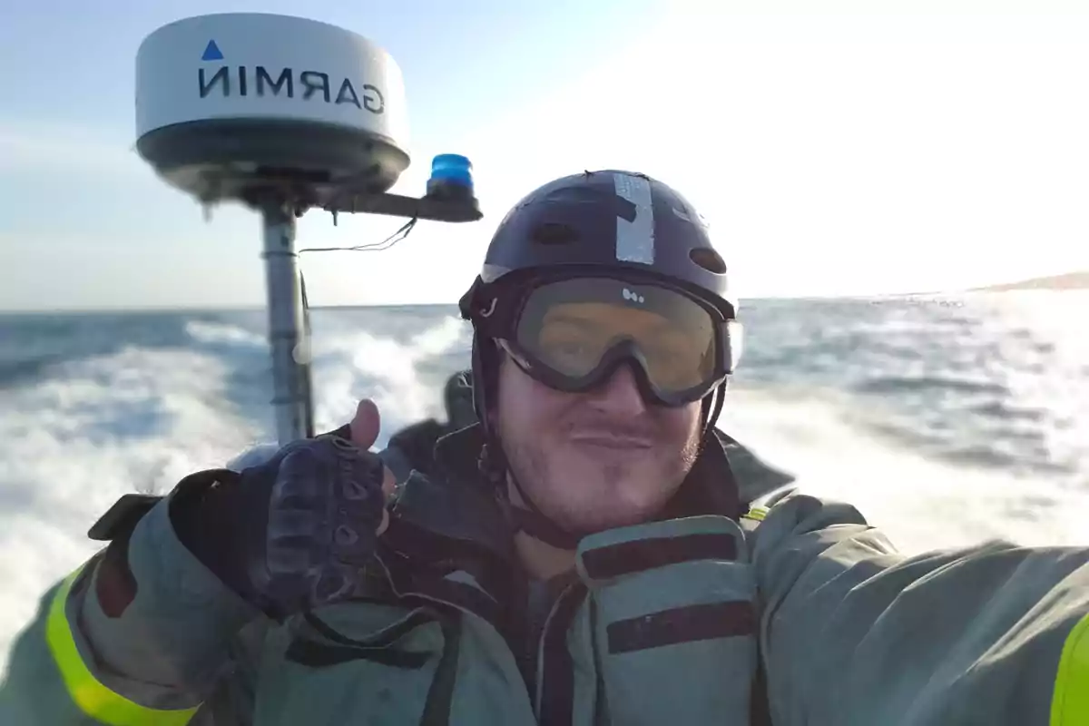Persona con casco y gafas de protección sonriendo en una lancha rápida en el mar. Persona con casco y gafas de protección sonriendo en una lancha rápida en el mar.