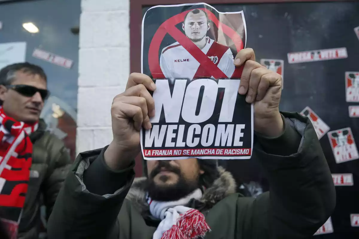 Aficionado del Rayo Vallecano con un cartel contra un jugador