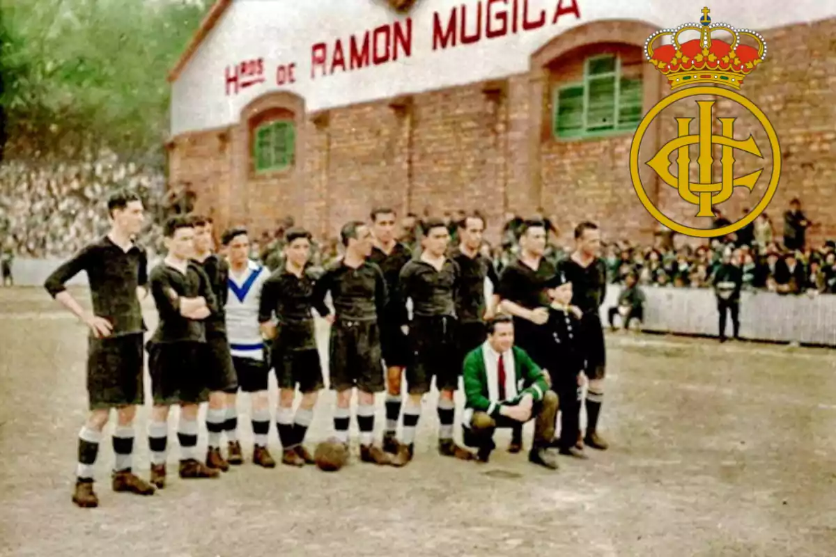 Equipo de fútbol posando en un campo de tierra frente a un edificio de ladrillo con el texto "Hijos de Ramón Múgica" y un escudo con corona a la derecha.