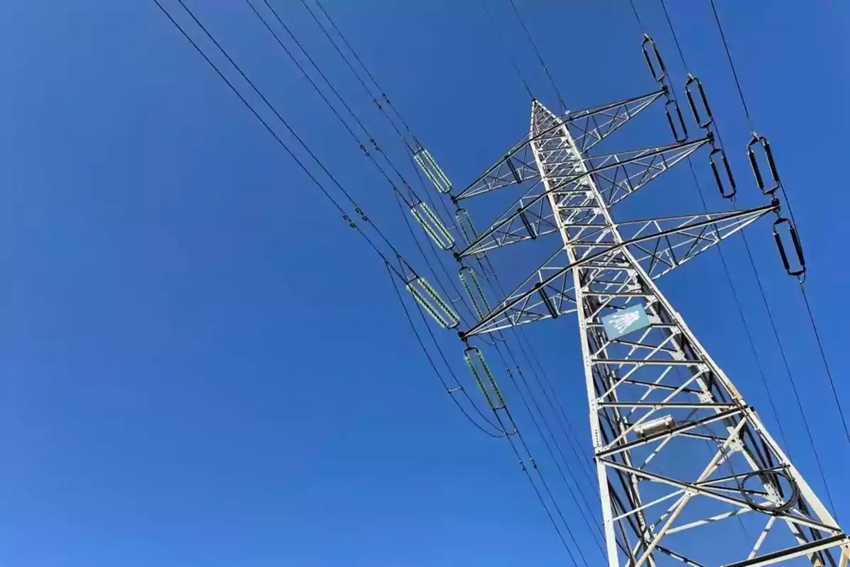 Torre de alta tensión con cables eléctricos bajo un cielo azul claro. Torre de alta tensión con cables eléctricos bajo un cielo azul claro.