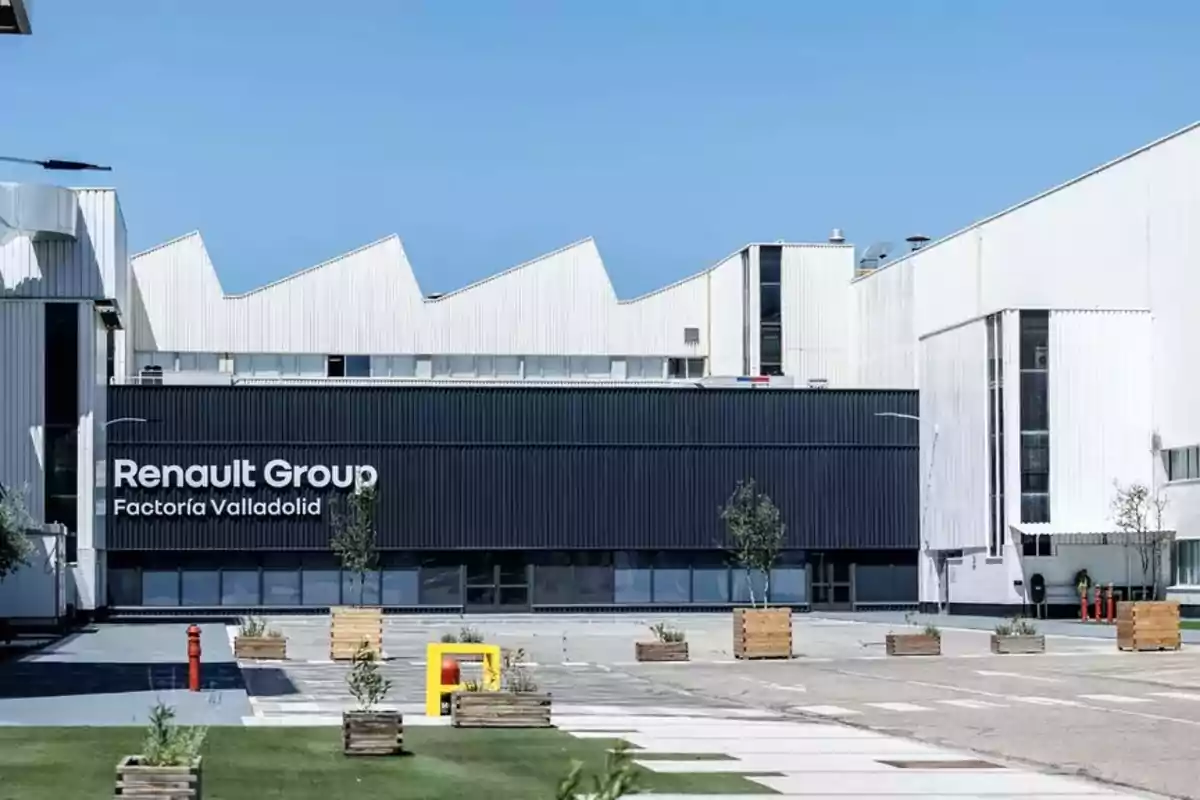 Vista de la fachada de la Factoría Renault Group en Valladolid con un cielo despejado y áreas verdes en el frente.