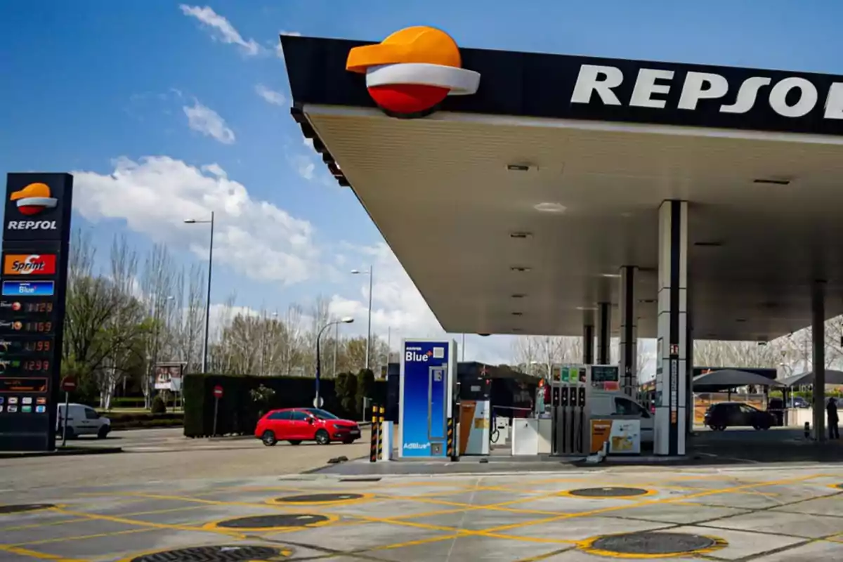 Una estación de servicio Repsol con surtidores y un cartel de precios de combustible en un día soleado.