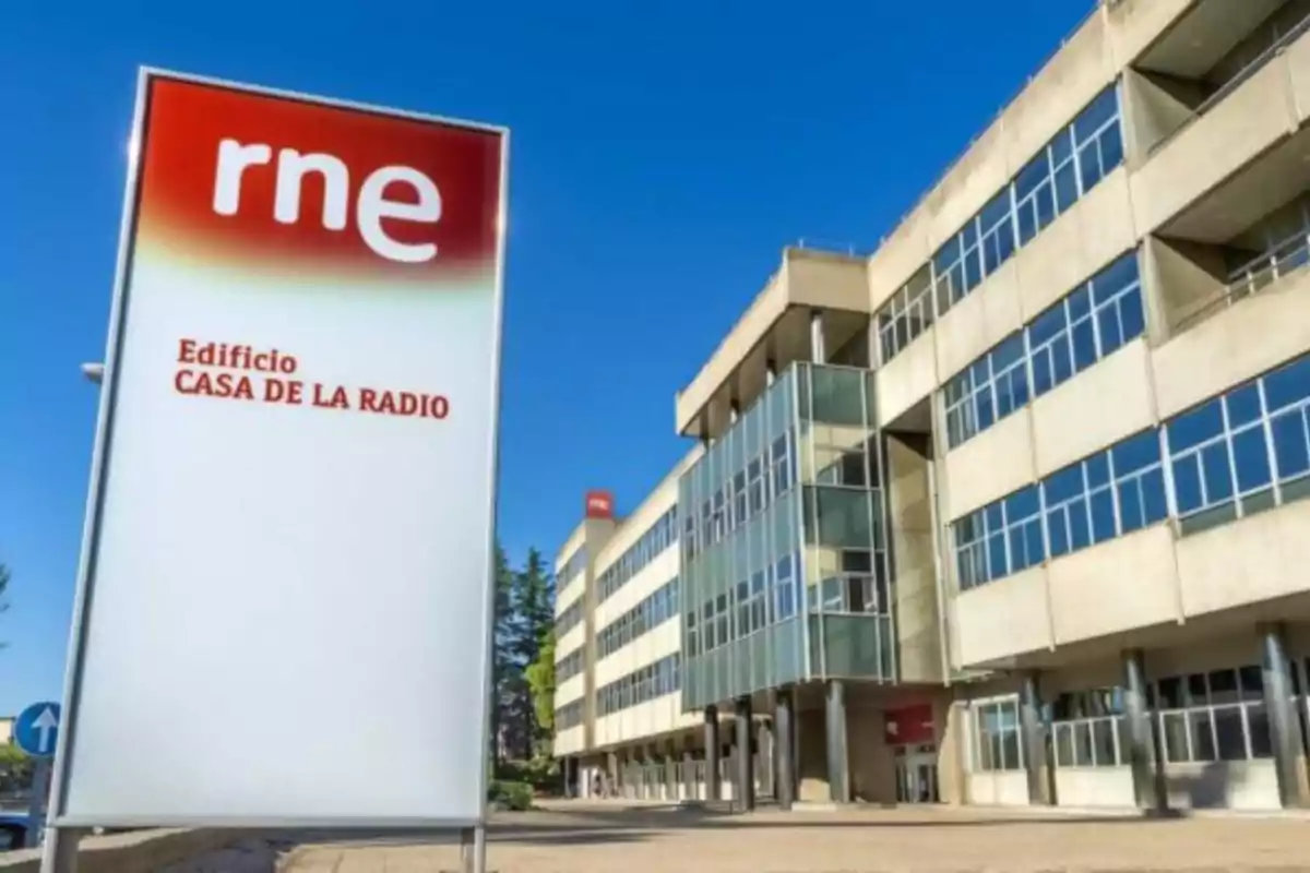 Edificio de la Casa de la Radio de RNE con un cartel en primer plano y el edificio de oficinas en el fondo.