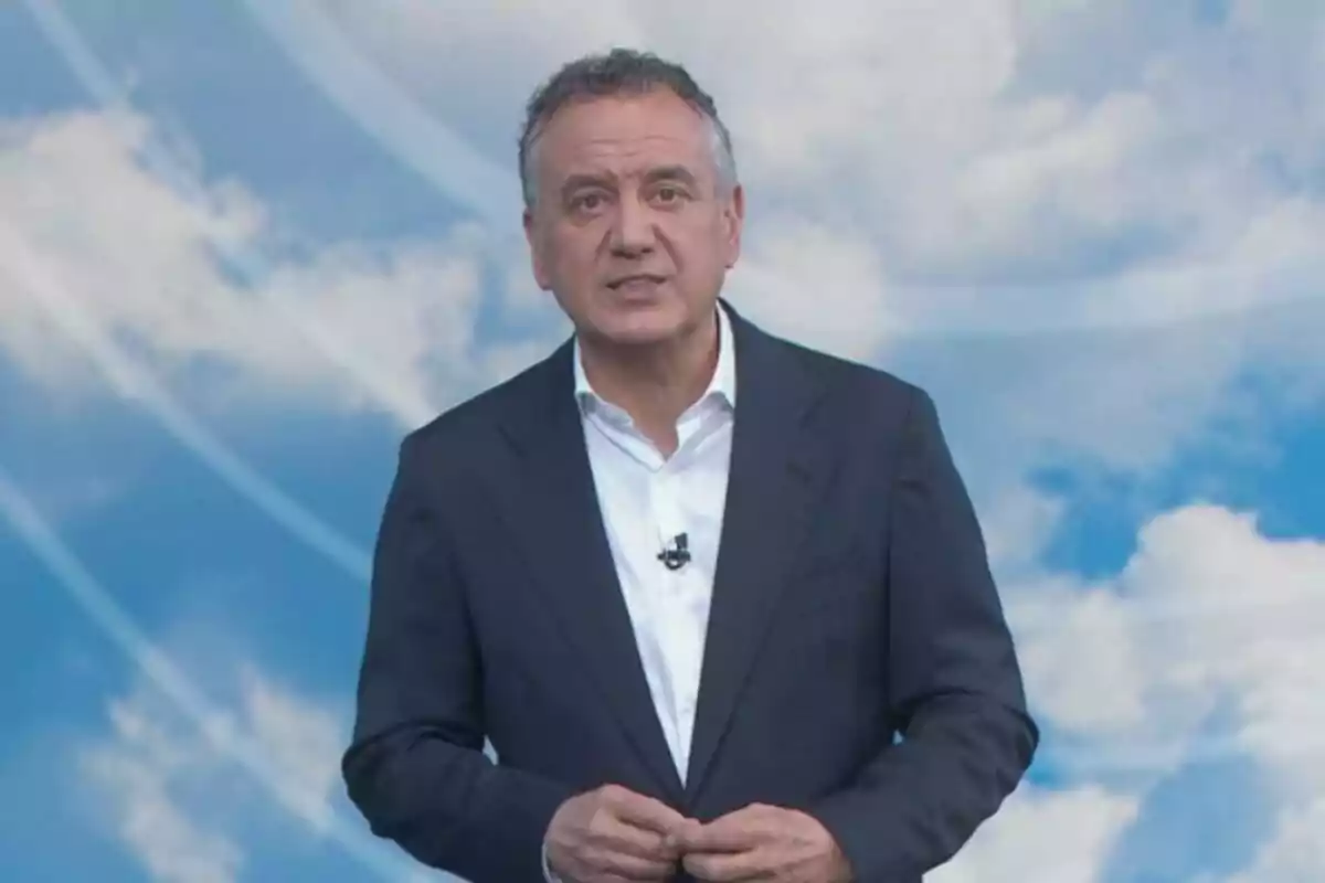 Roberto Brasero con traje oscuro y camisa blanca está de pie frente a un fondo de cielo azul con nubes. Roberto Brasero con traje oscuro y camisa blanca está de pie frente a un fondo de cielo azul con nubes.