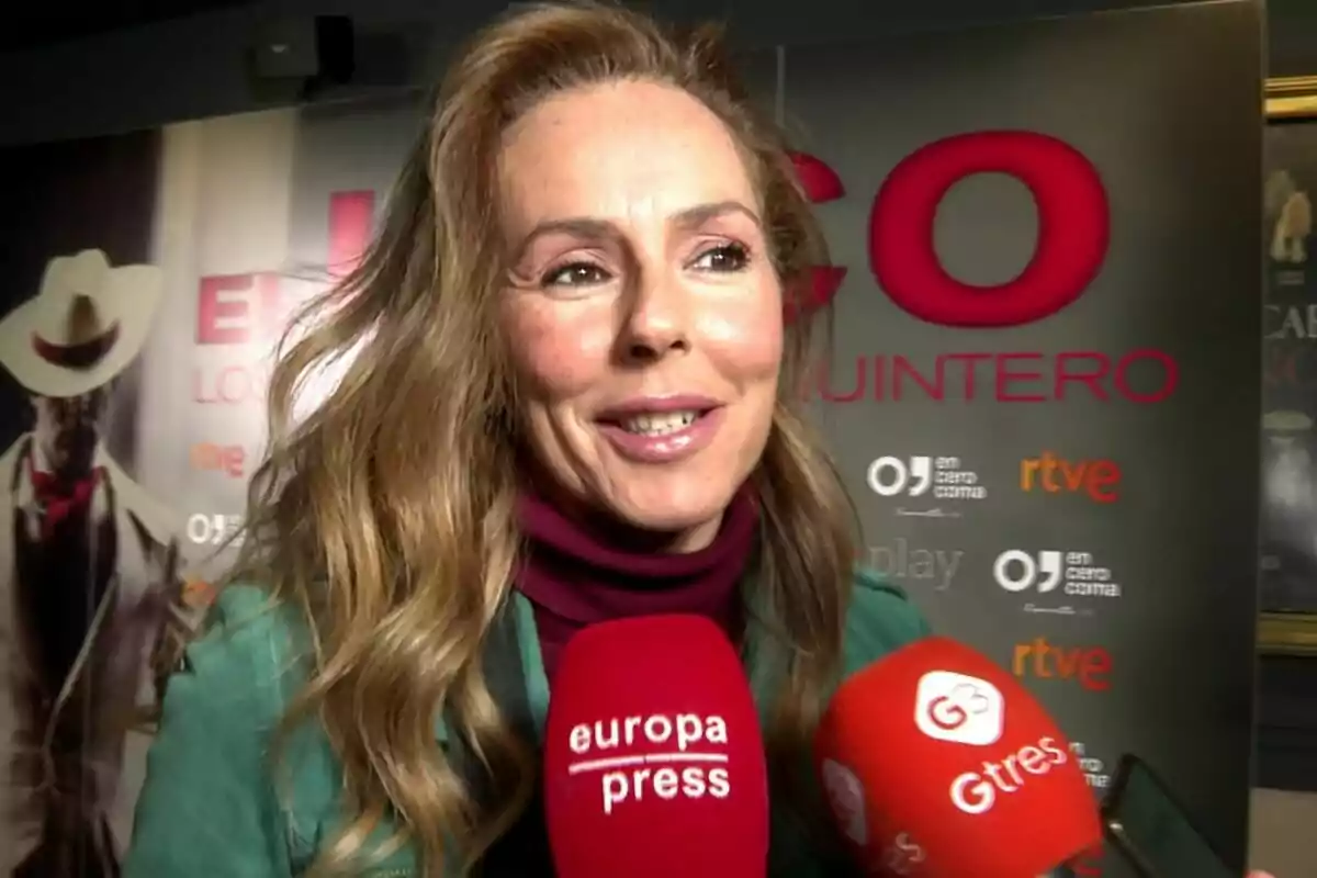 Rocío Carrasco sonriendo frente a varios micrófonos de prensa en un evento.