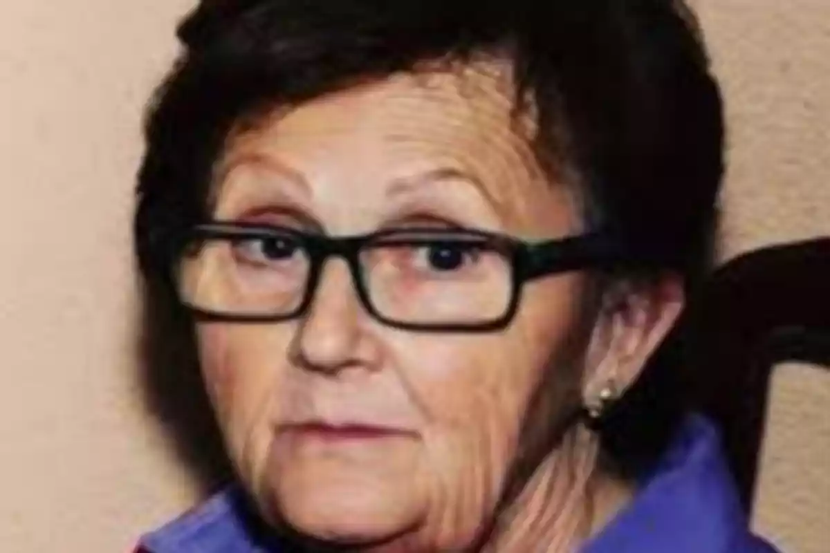 Una persona mayor con gafas y cabello corto oscuro mira hacia adelante con una expresión neutral. Una persona mayor con gafas y cabello corto oscuro mira hacia adelante con una expresión neutral.