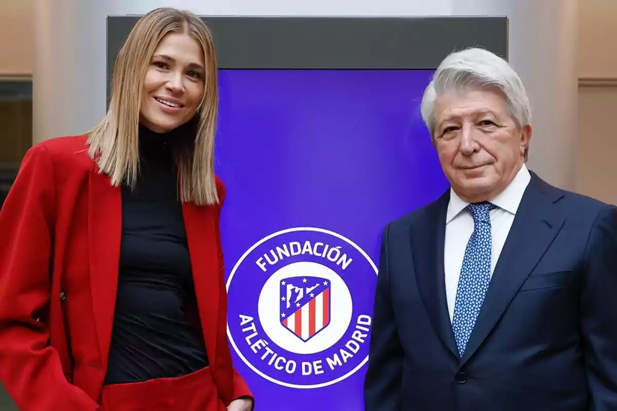 Dos personas posan frente a un cartel de la Fundación Atlético de Madrid.
