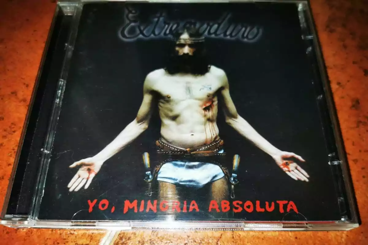 Portada de un disco de Extremoduro titulado Yo, minoría absoluta que muestra a un hombre semidesnudo con corona de espinas y heridas en el pecho y las manos Portada de un disco de Extremoduro titulado Yo, minoría absoluta que muestra a un hombre semidesnudo con corona de espinas y heridas en el pecho y las manos