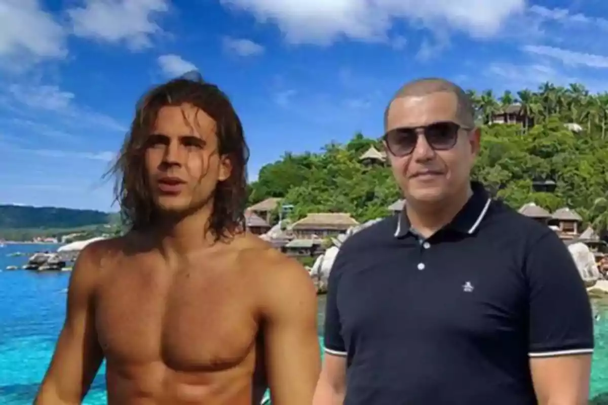 Dos hombres posan frente a un paisaje tropical con mar azul y vegetación.