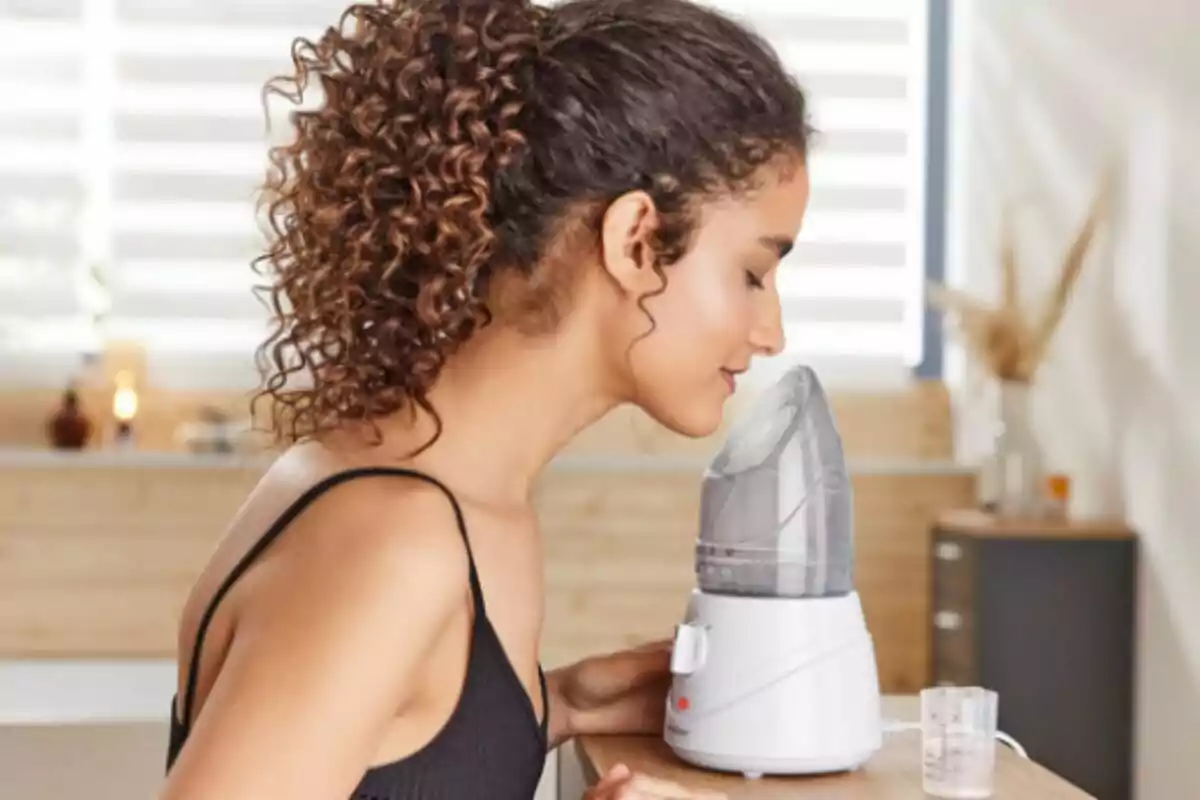 Mujer usando un vaporizador facial de Lidl en un ambiente relajado. Mujer usando un vaporizador facial de Lidl en un ambiente relajado.