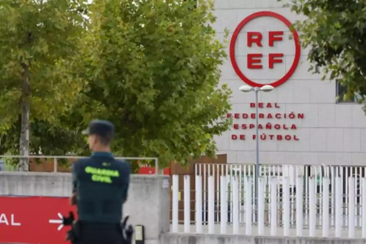 Un guardia civil de espaldas frente al edificio de la Real Federación Española de Fútbol.