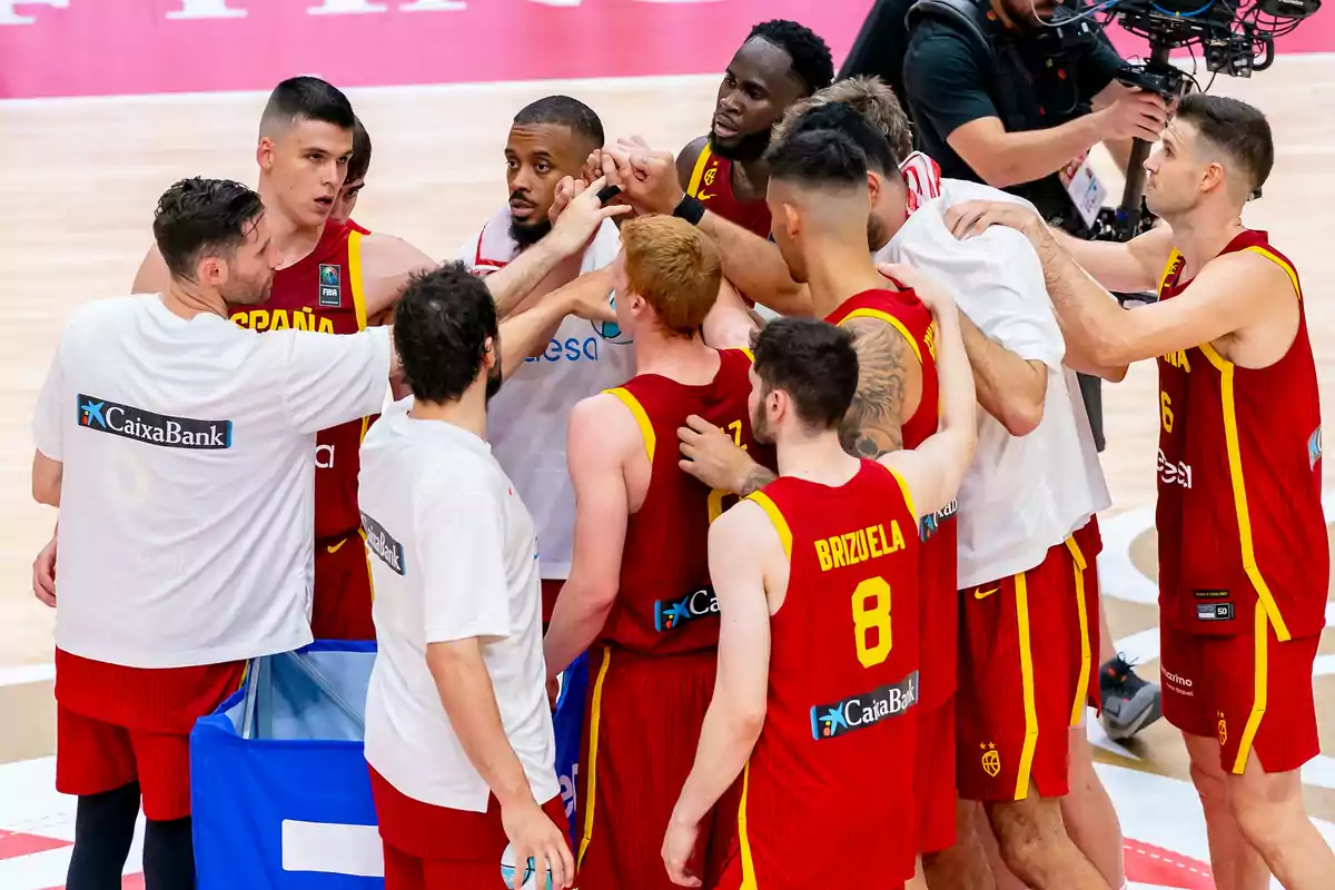 Jugadores de baloncesto del equipo de España se reúnen en un círculo para darse ánimos antes de un partido.