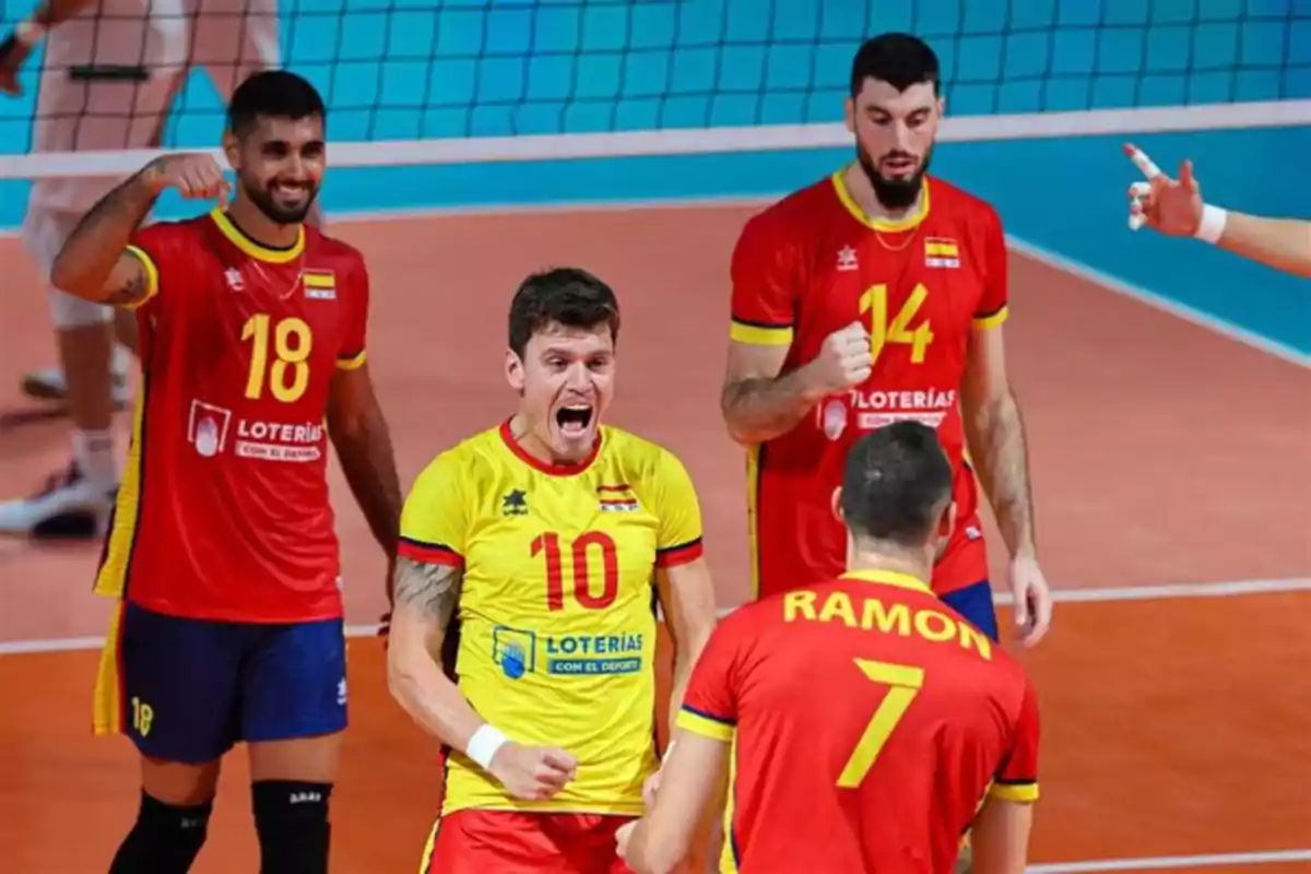 Jugadores de voleibol celebrando un punto en la cancha.