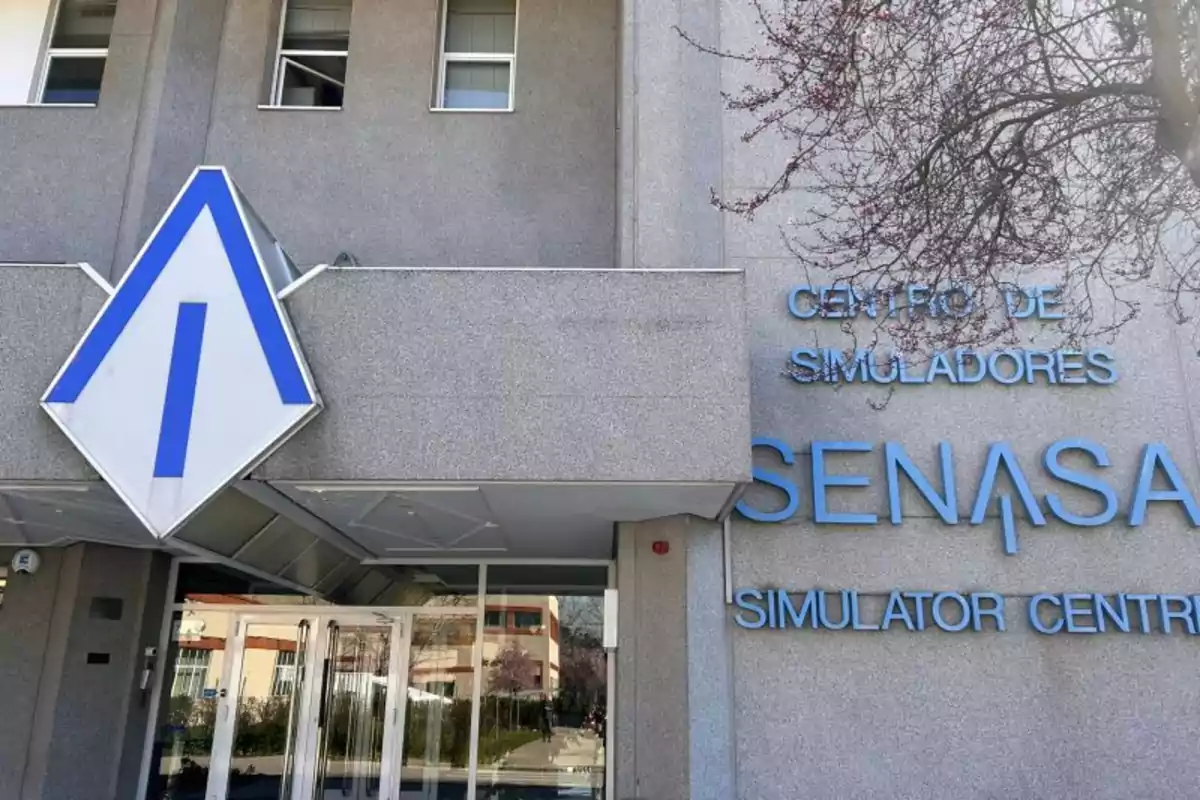 Edificio gris con un letrero que dice "Centro de Simuladores SENASA Simulator Centre" y un logotipo azul en forma de flecha.