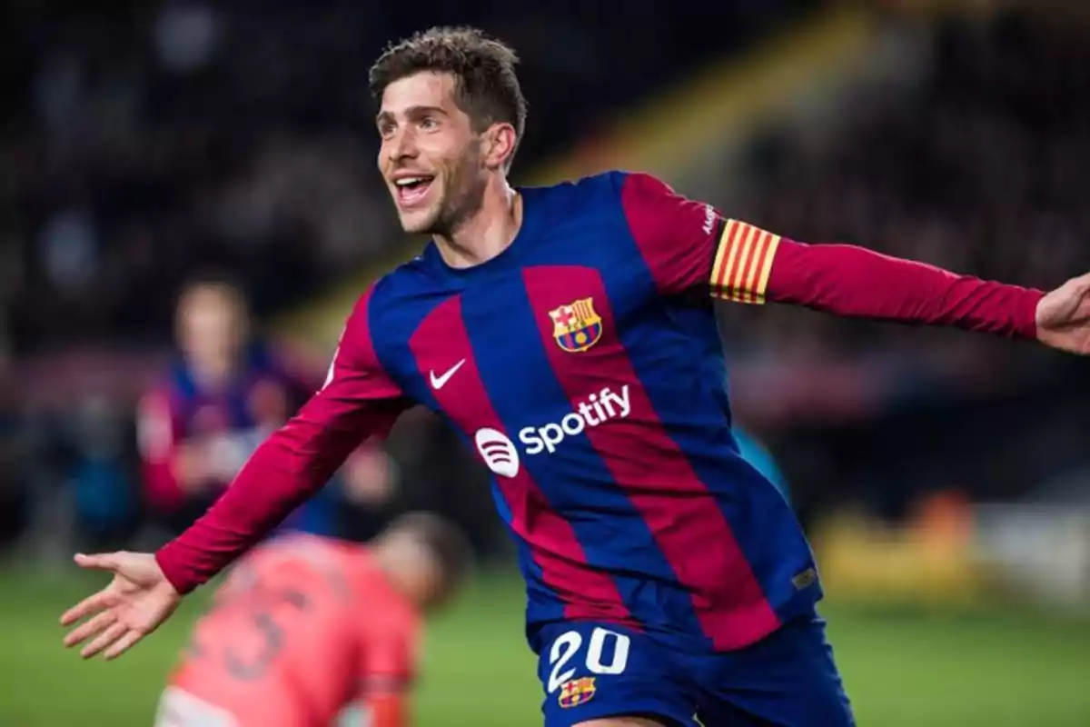 Jugador de fútbol del FC Barcelona celebrando un gol con los brazos extendidos.