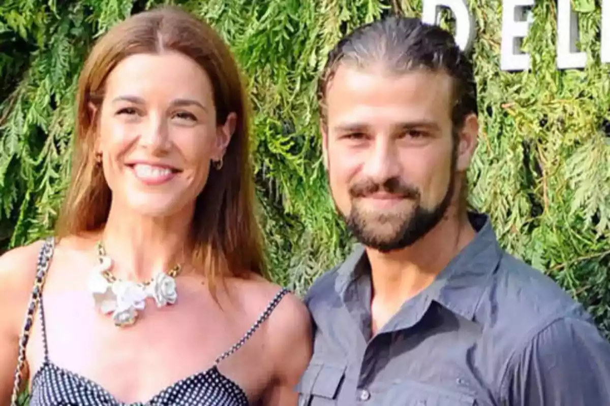 Una mujer y un hombre sonríen juntos al aire libre con un fondo de vegetación verde. Una mujer y un hombre sonríen juntos al aire libre con un fondo de vegetación verde.