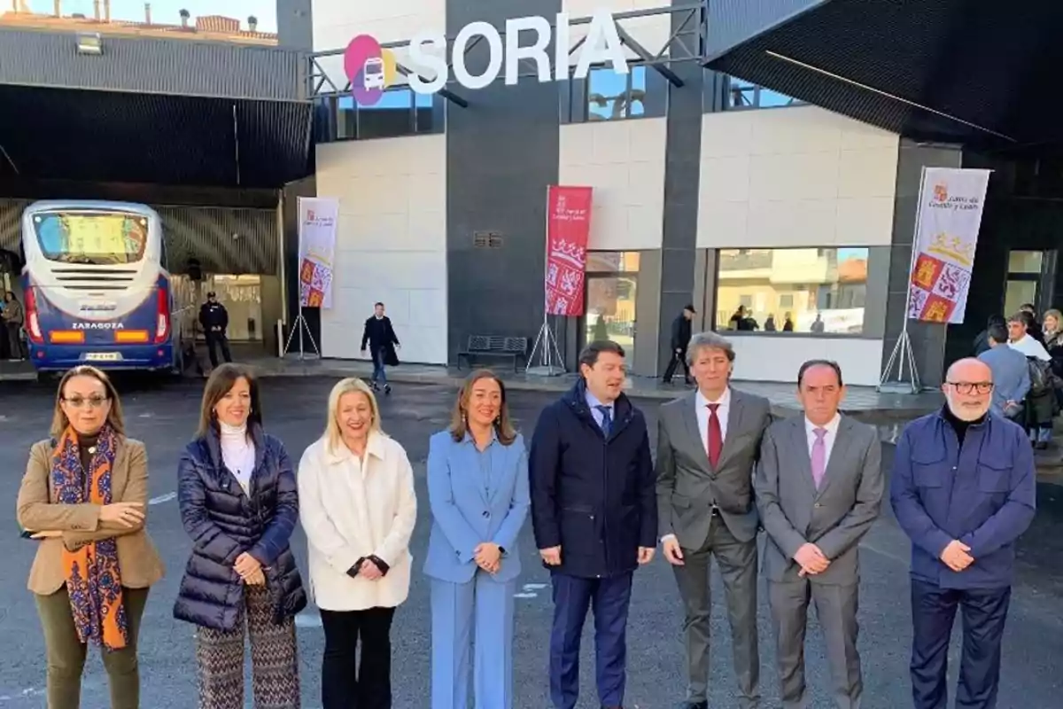Ocho personas posan frente a la estación de autobuses de Soria, con un autobús y el letrero de Soria visibles al fondo. Ocho personas posan frente a la estación de autobuses de Soria, con un autobús y el letrero de Soria visibles al fondo.
