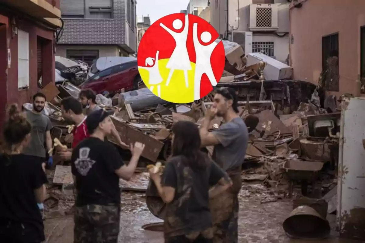 Un grupo de personas se encuentra en una calle llena de escombros y vehículos dañados, con un logotipo superpuesto en el centro de la imagen.