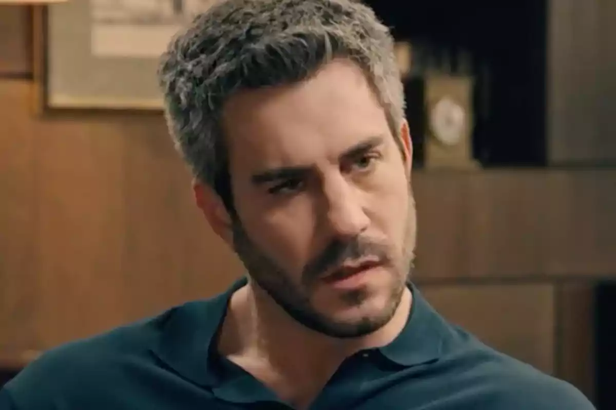 Andrés con barba y cabello corto y canoso lleva una camiseta oscura y está en un ambiente interior con paredes de madera. Captura de 'Sueños de libertad' Andrés con barba y cabello corto y canoso lleva una camiseta oscura y está en un ambiente interior con paredes de madera. Captura de 'Sueños de libertad'