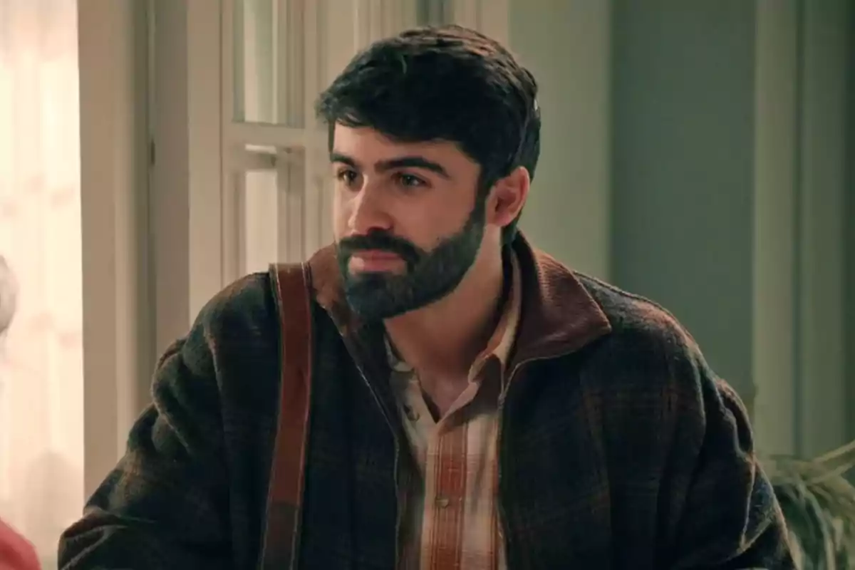 Raúl con barba y cabello oscuro lleva una chaqueta de cuadros y una camisa de cuadros mientras está en un interior iluminado. Captura de 'Sueños de libertad' Raúl con barba y cabello oscuro lleva una chaqueta de cuadros y una camisa de cuadros mientras está en un interior iluminado. Captura de 'Sueños de libertad'