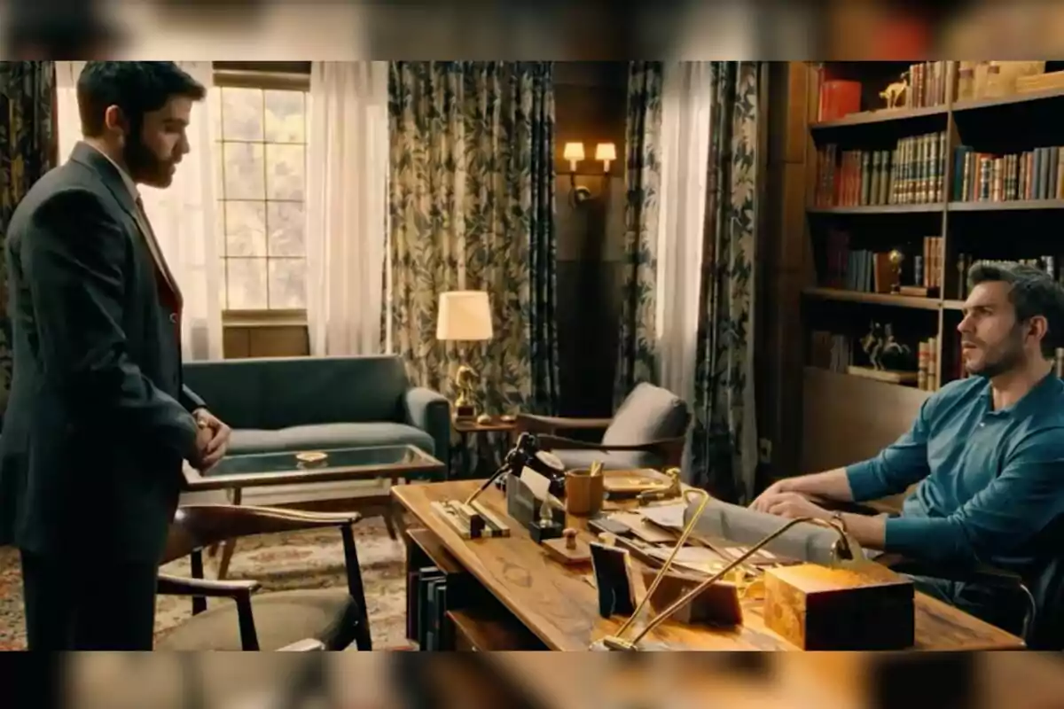 Raúl y Andrés conversan en una oficina elegante con estanterías llenas de libros y muebles clásicos. Captura de 'Sueños de libertad' Raúl y Andrés conversan en una oficina elegante con estanterías llenas de libros y muebles clásicos. Captura de 'Sueños de libertad'