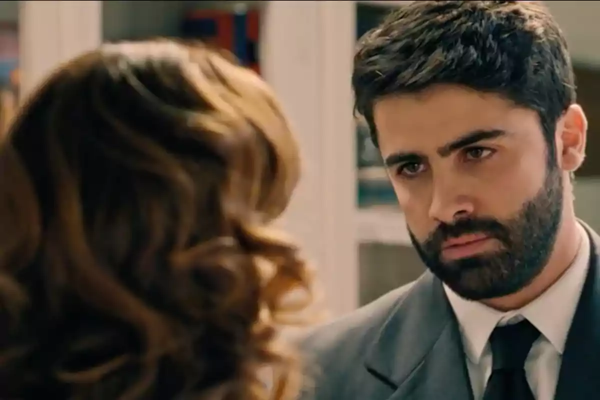 Raúl de barba y cabello oscuro con expresión seria mirando a una mujer de cabello ondulado. Captura de 'Sueños de libertad' Raúl de barba y cabello oscuro con expresión seria mirando a una mujer de cabello ondulado. Captura de 'Sueños de libertad'