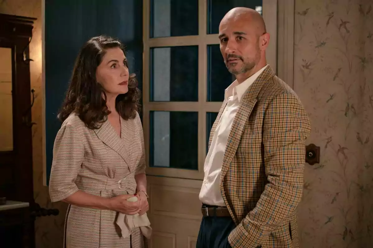 Ana Fernández y Alain Hernández están de pie en una habitación con papel tapiz floral y una puerta de vidrio detrás de ellos en Sueños de Libertad. Ana Fernández y Alain Hernández están de pie en una habitación con papel tapiz floral y una puerta de vidrio detrás de ellos en Sueños de Libertad.