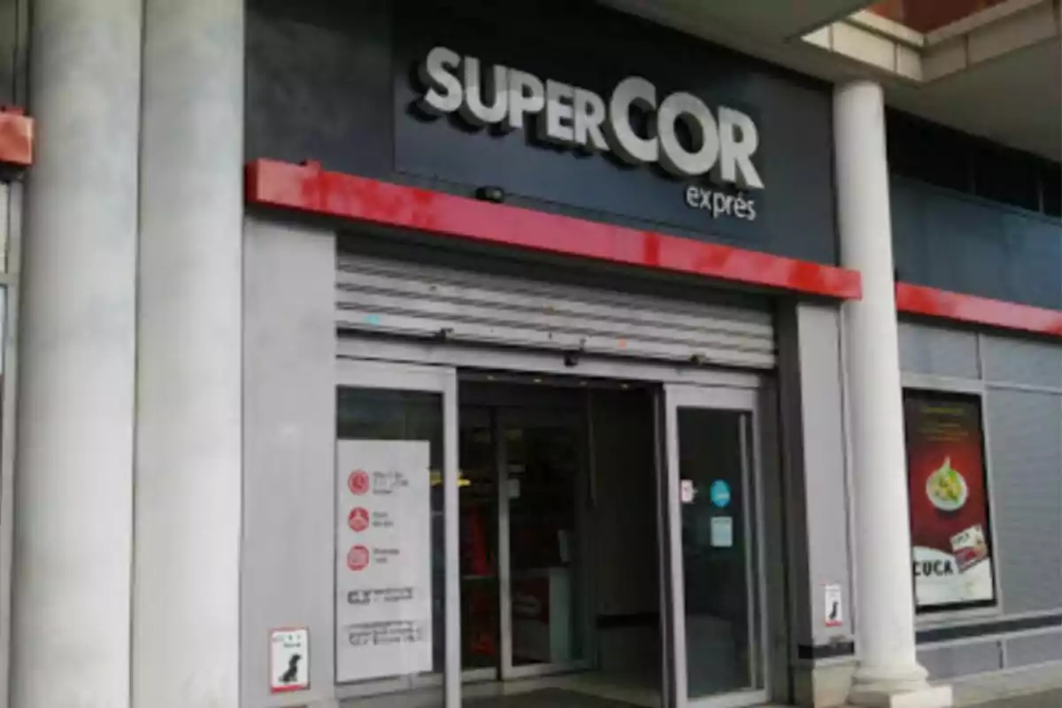 Entrance to a Supercor Exprés store with glass doors and signs on the facade. Entrance to a Supercor Exprés store with glass doors and signs on the facade.