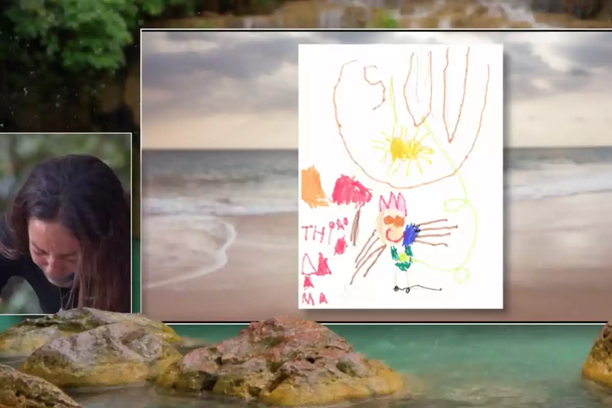 Anita aparece emocionada junto a un dibujo infantil colorido que muestra un sol, una figura sonriente y varias formas abstractas, todo sobre un fondo de playa con rocas y el mar. Captura de 'Supervivientes' Anita aparece emocionada junto a un dibujo infantil colorido que muestra un sol, una figura sonriente y varias formas abstractas, todo sobre un fondo de playa con rocas y el mar. Captura de 'Supervivientes'