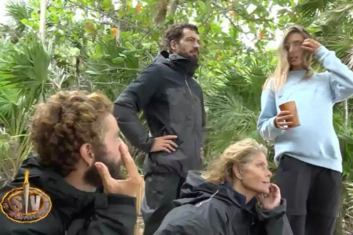 Un grupo de personas vestidas con ropa oscura se encuentra en un entorno selvático, rodeados de vegetación, mientras una de ellas sostiene un vaso. Captura de 'Supervivientes' Un grupo de personas vestidas con ropa oscura se encuentra en un entorno selvático, rodeados de vegetación, mientras una de ellas sostiene un vaso. Captura de 'Supervivientes'