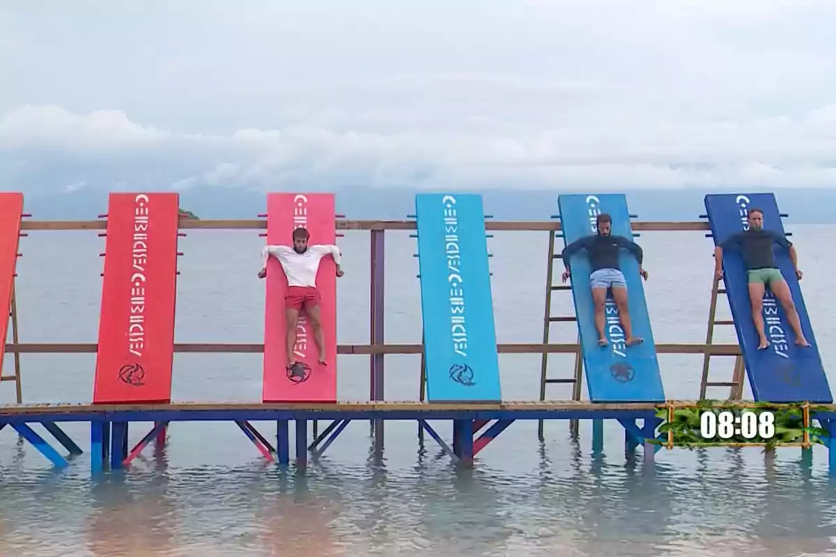 Cuatro personas están acostadas en tablas inclinadas sobre el agua, participando en un desafío en la playa. Captura de 'Supervivientes' Cuatro personas están acostadas en tablas inclinadas sobre el agua, participando en un desafío en la playa. Captura de 'Supervivientes'
