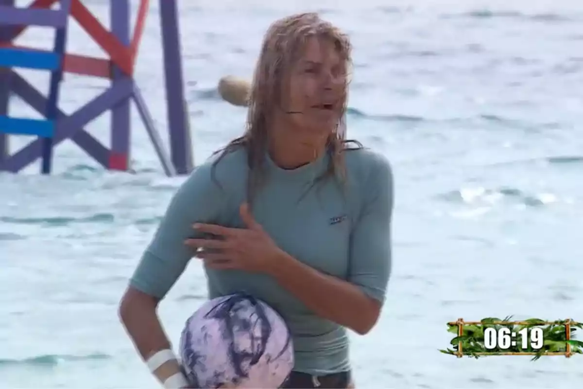 Makoke con camiseta azul claro sostiene una pelota en la playa, con el mar de fondo y un cronómetro en la esquina inferior derecha. Captura de 'Supervivientes' Makoke con camiseta azul claro sostiene una pelota en la playa, con el mar de fondo y un cronómetro en la esquina inferior derecha. Captura de 'Supervivientes'