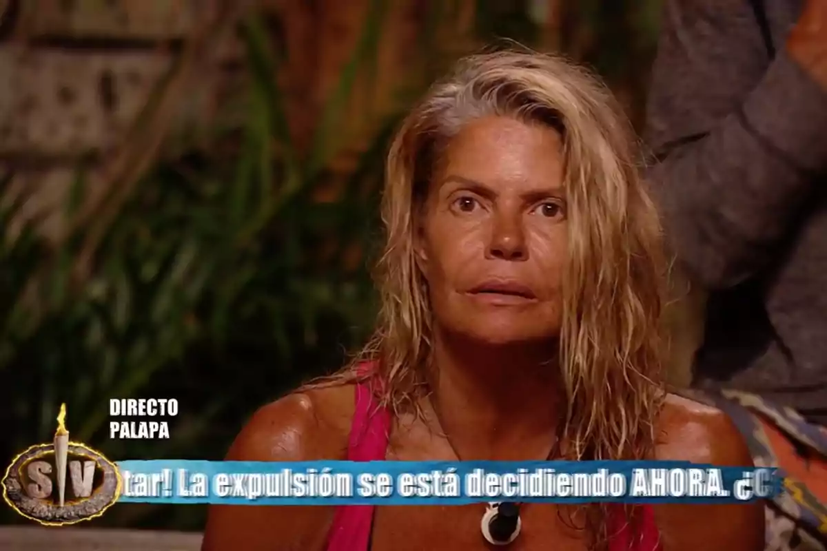 Makoke con expresión seria, sentada en un entorno selvático durante un programa de televisión en vivo, con un cintillo azul en la parte inferior de la imagen que muestra texto sobre una expulsión. Captura de 'Supervivientes' Makoke con expresión seria, sentada en un entorno selvático durante un programa de televisión en vivo, con un cintillo azul en la parte inferior de la imagen que muestra texto sobre una expulsión. Captura de 'Supervivientes'