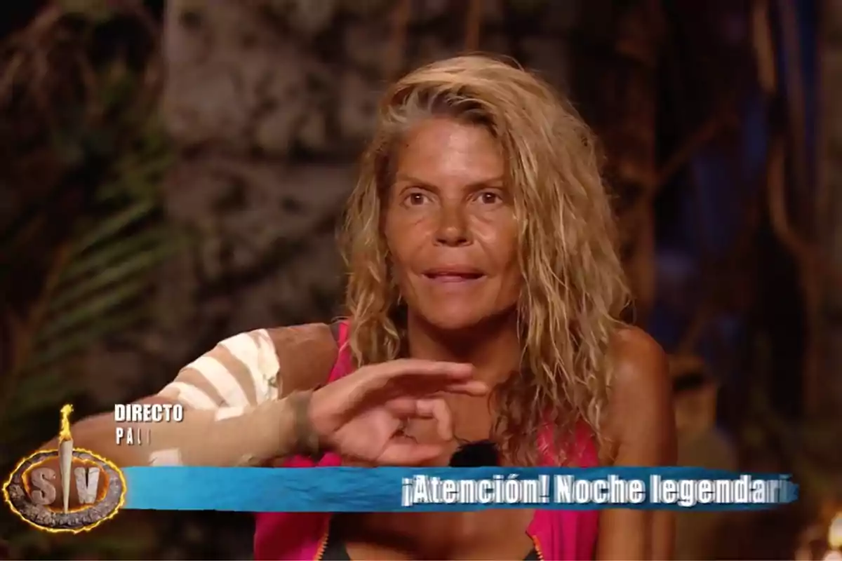 Makoke, vestida con una camiseta sin mangas rosa, aparece en un programa de televisión en vivo con un fondo que parece ser una selva o bosque, mientras un texto en la parte inferior de la imagen dice Makoke, vestida con una camiseta sin mangas rosa, aparece en un programa de televisión en vivo con un fondo que parece ser una selva o bosque, mientras un texto en la parte inferior de la imagen dice