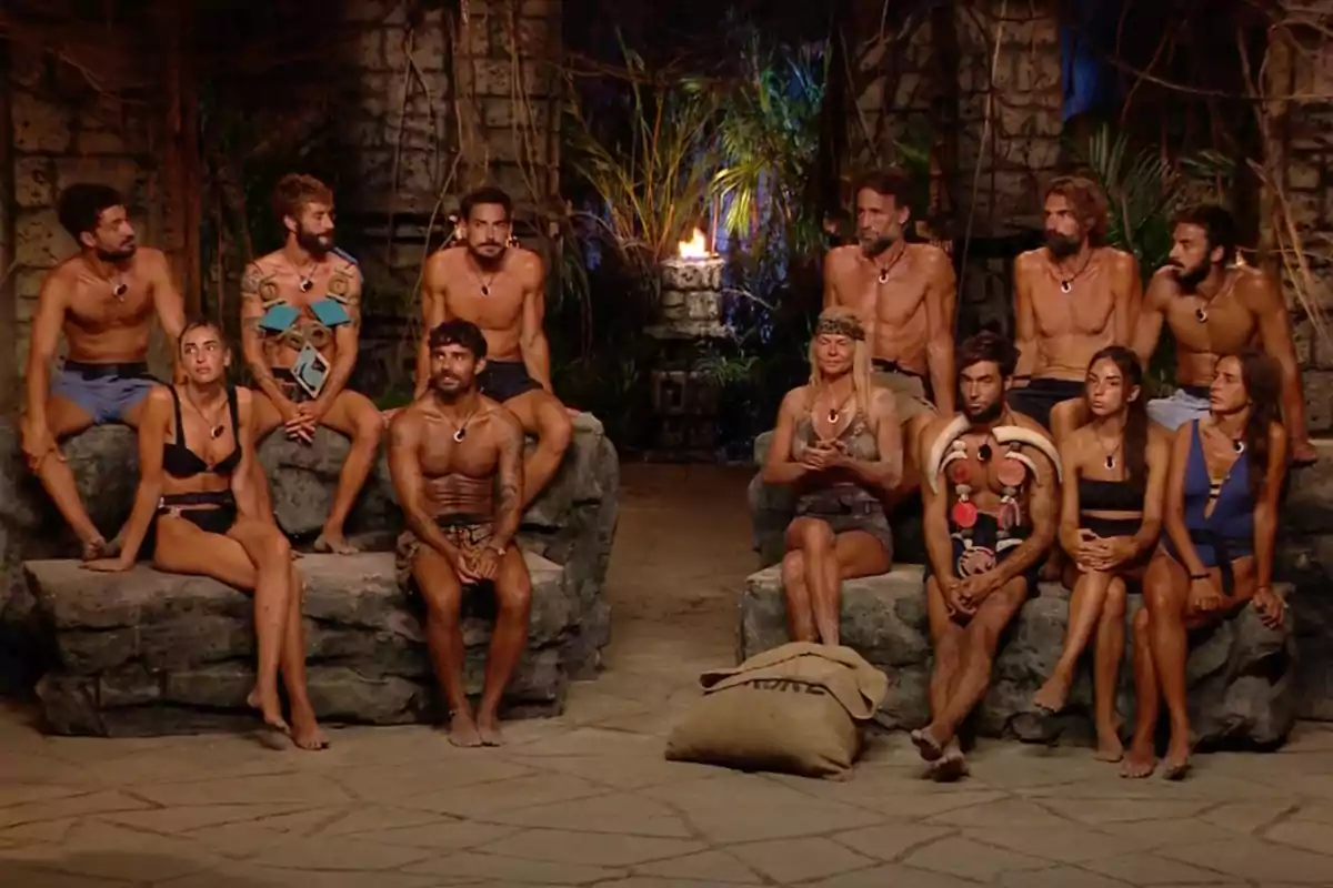 Un grupo de personas sentadas en un entorno de estilo tribal con una antorcha encendida al fondo. Captura de 'Supervivientes' Un grupo de personas sentadas en un entorno de estilo tribal con una antorcha encendida al fondo. Captura de 'Supervivientes'