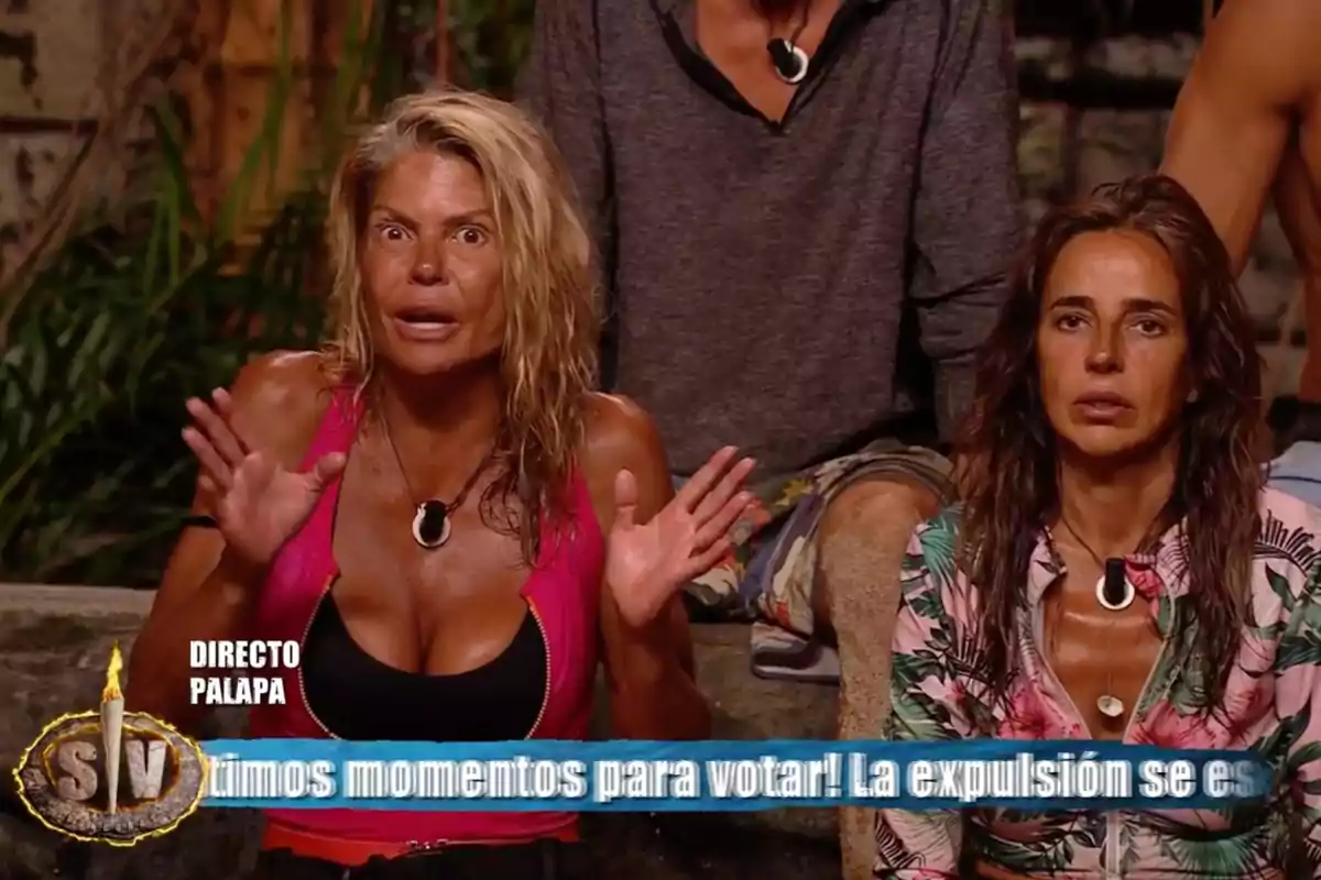 Makoke y Carmen Alcayde con expresión seria y sorprendida sentadas en un set de televisión de un reality show de supervivencia con un rótulo azul en la parte inferior de la imagen. Captura de 'Supervivientes' Makoke y Carmen Alcayde con expresión seria y sorprendida sentadas en un set de televisión de un reality show de supervivencia con un rótulo azul en la parte inferior de la imagen. Captura de 'Supervivientes'