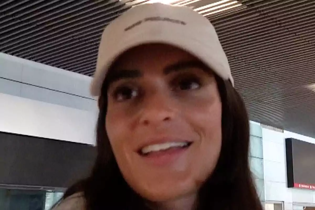 Susana Molina con gorra sonríe en un lugar público con techo de paneles. Susana Molina con gorra sonríe en un lugar público con techo de paneles.