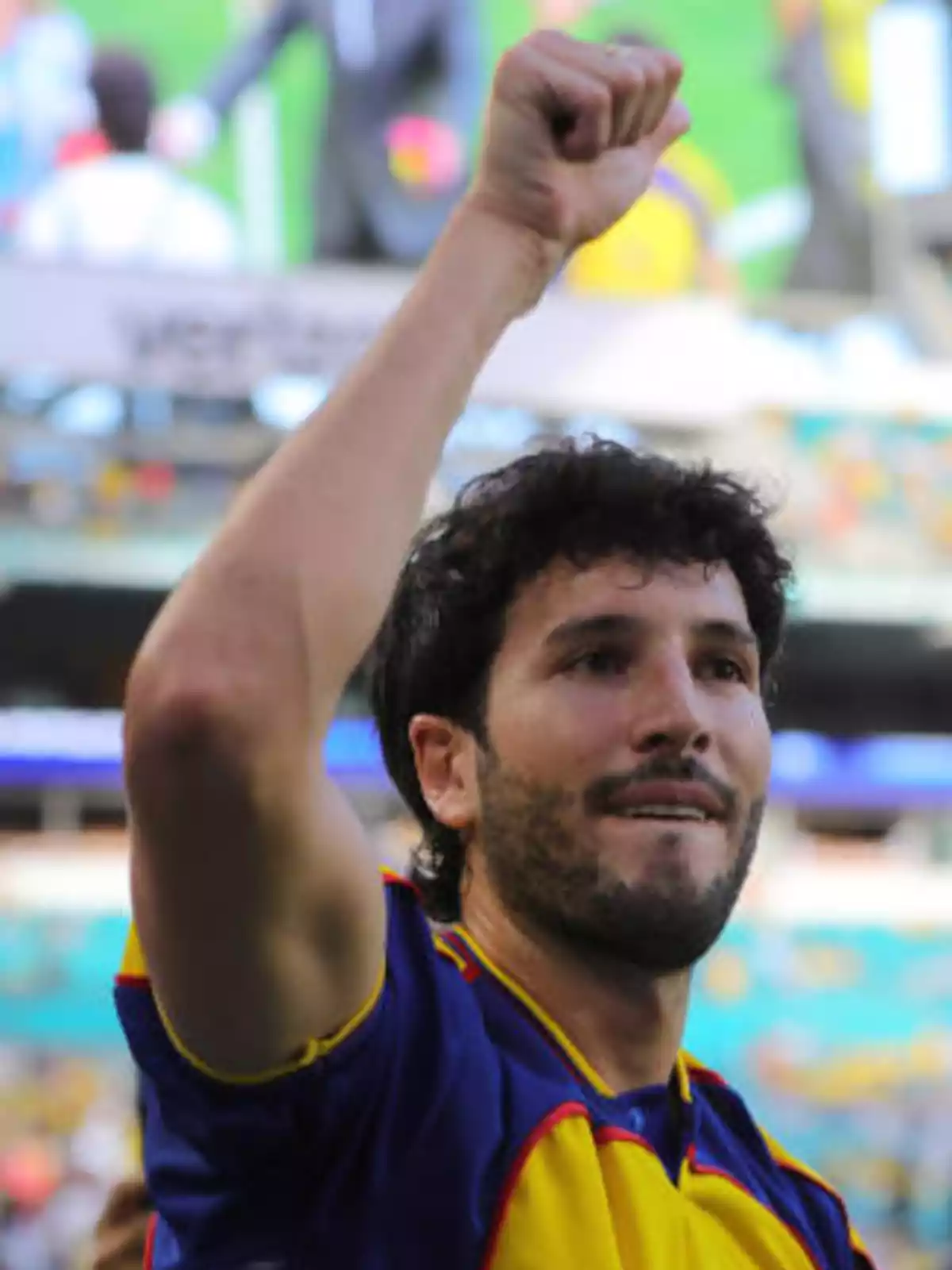 Un jugador de fútbol levantando el brazo en señal de celebración durante un partido.