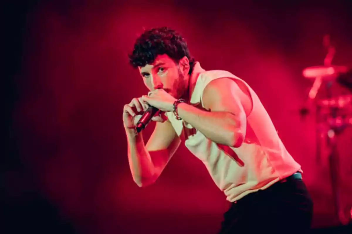 Cantante actuando en un escenario con iluminación roja.