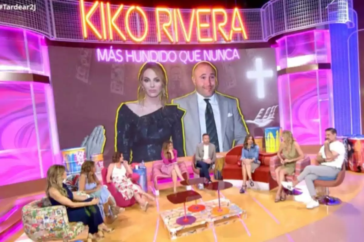 Un grupo de personas está sentado en un set de televisión colorido con una gran pantalla al fondo que muestra a una pareja y el texto Kiko Rivera más hundido que nunca. Captura de 'TardeAR' Un grupo de personas está sentado en un set de televisión colorido con una gran pantalla al fondo que muestra a una pareja y el texto Kiko Rivera más hundido que nunca. Captura de 'TardeAR'