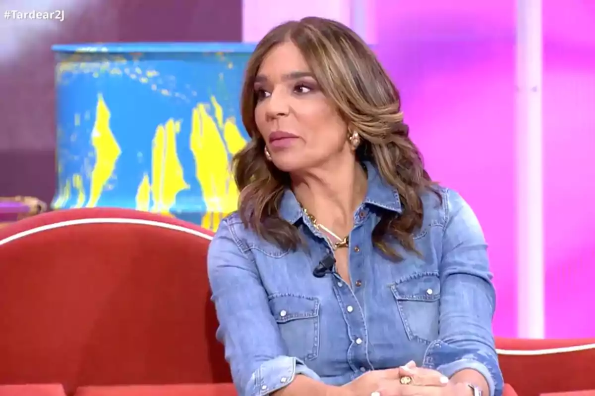 Raquel Bollo sentada en un sofá rojo con camisa de mezclilla en un set de televisión con fondo colorido. Captura de 'TardeAR' Raquel Bollo sentada en un sofá rojo con camisa de mezclilla en un set de televisión con fondo colorido. Captura de 'TardeAR'