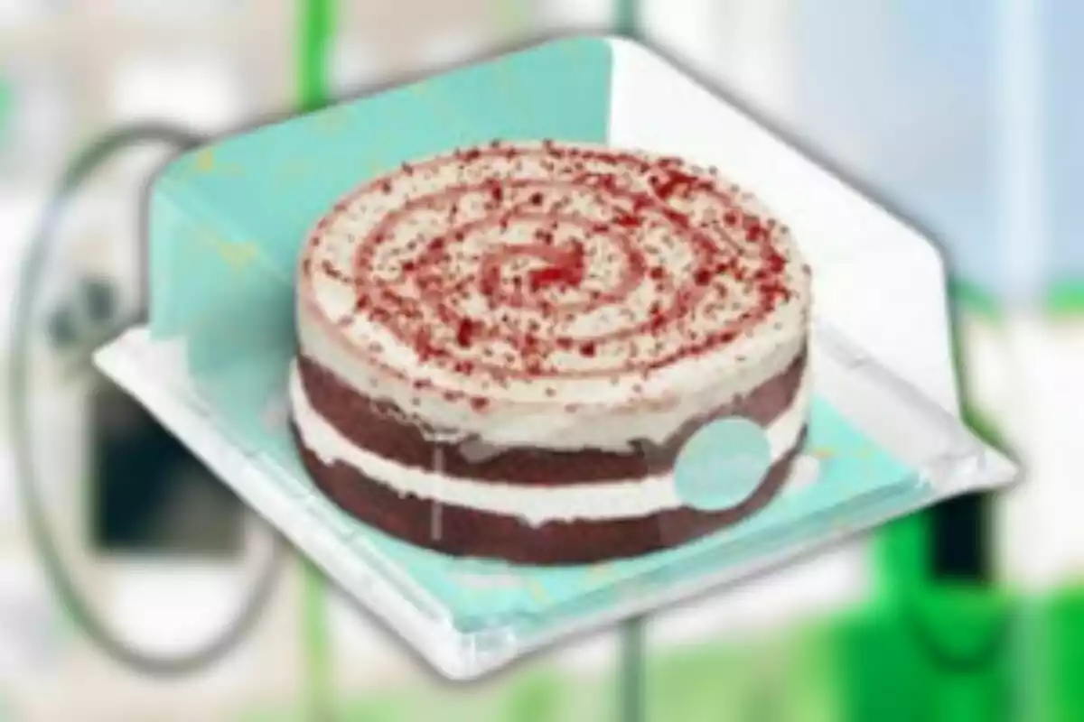 Una torta de capas con crema blanca y espolvoreada con migas rojas sobre un plato azul. Una torta de capas con crema blanca y espolvoreada con migas rojas sobre un plato azul.